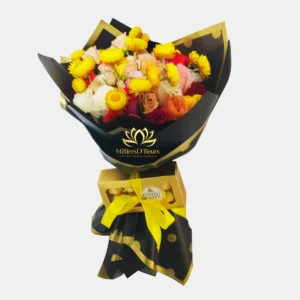 "Bouquet floral Destellos de Oro con flores amarillas, rosas variadas y caja de bombones Ferrero Rocher en envoltorio negro con dorado de Milliers D'fleurs."