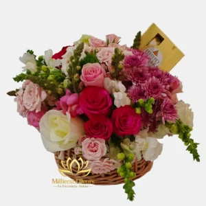 "Cesta de mimbre Suspiro Floral con rosas rosadas y fucsias, flores blancas y una caja de chocolates Ferrero Rocher de Milliers D'fleurs."