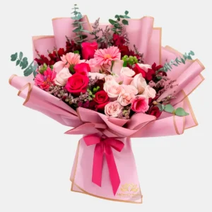 "Bouquet de flores Blush Premium con rosas rosadas, gerberas y eucalipto en envoltorio rosa con lazo de Milliers D'fleurs."