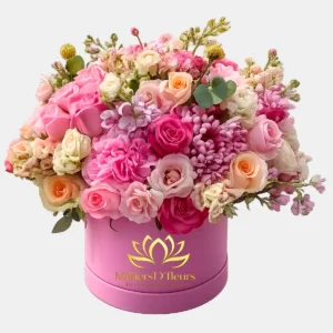 Arreglo floral en caja rosa con rosas fucsia y lilas de MilliersD'fleurs Guayaquil.