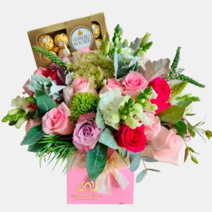 Arreglo floral de MillersD'fleurs en Guayaquil con rosas rosadas, fucsias, flores blancas, follaje verde y caja de chocolates Ferrero Rocher en box rosa.