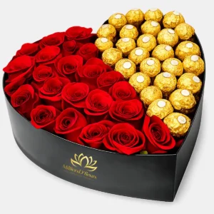 Arreglo floral en caja negra con forma de corazón de MilliersD'fleurs, dividido con rosas rojas a la izquierda y chocolates Ferrero Rocher a la derecha.