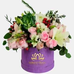Arreglo floral con flores en tonos pastel en caja lila