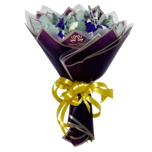 Bouquet de flores azules con elegante papel coreano morado y lazo amarillo para entrega a domicilio en Guayaquil con MilliersD'fleurs.